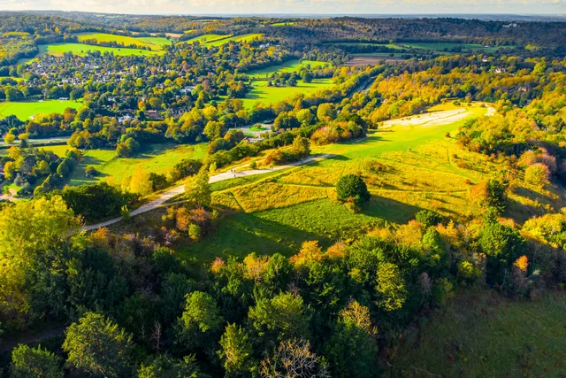 Aerial photograph of fields, woodland and roads in England.