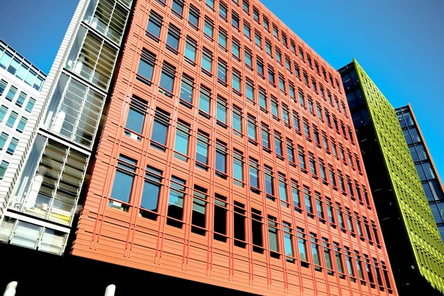 Brick and glass office buildings photographed from below in Soho, London.